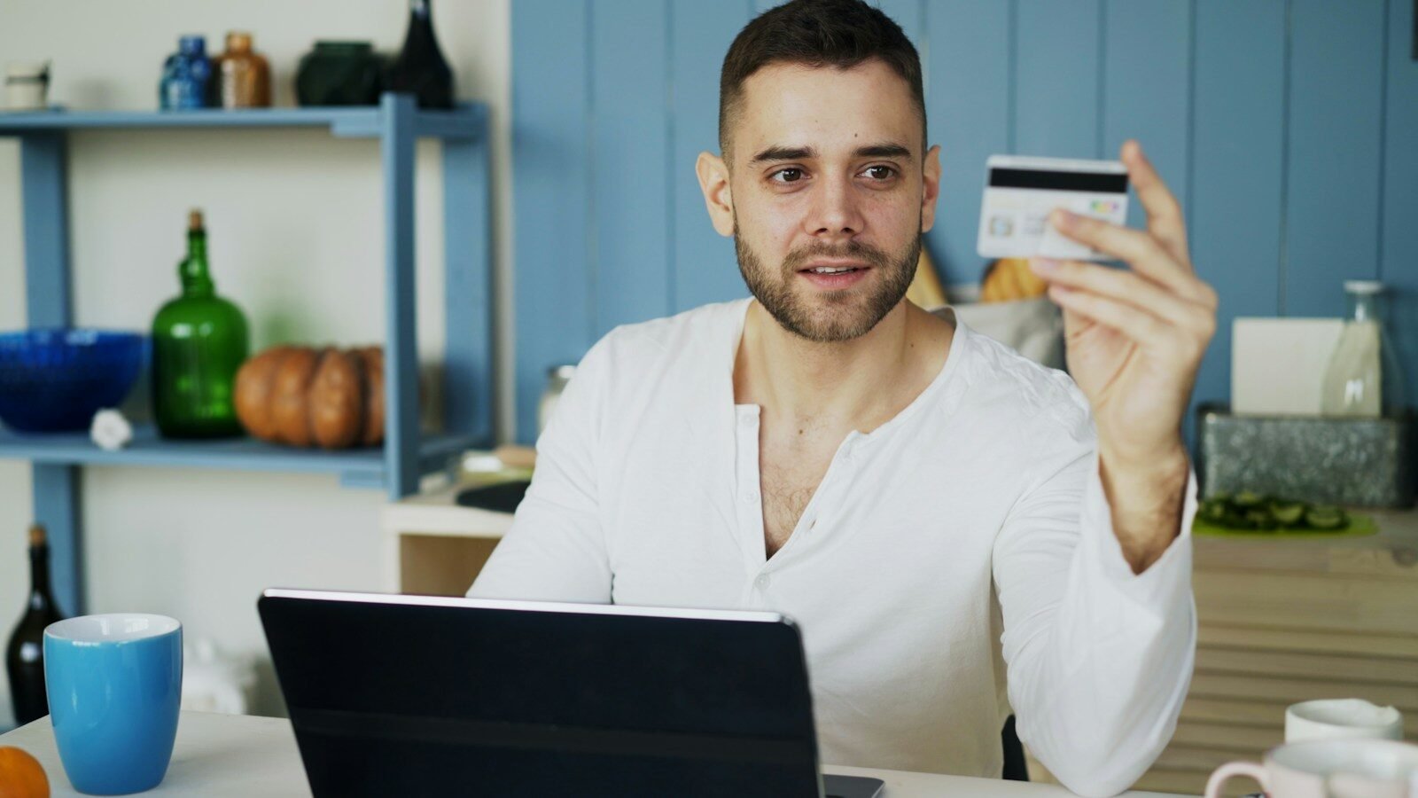 Man holding credit card while looking at laptop