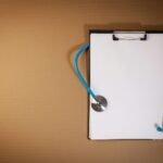 Clipboard with stethoscope on a brown background