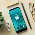 A smartphone displaying a security lock icon on a wooden desk with a succulent